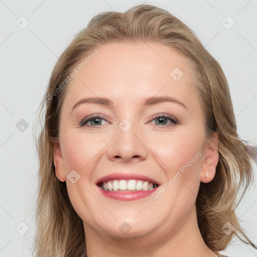 Joyful white young-adult female with long  brown hair and blue eyes