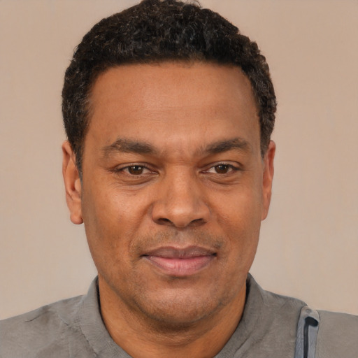 Joyful latino adult male with short  black hair and brown eyes