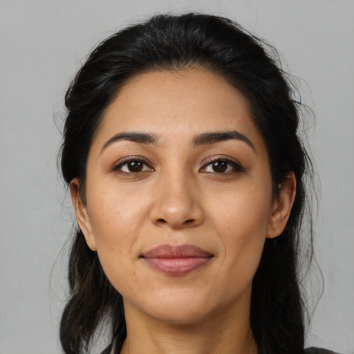 Joyful latino young-adult female with medium  brown hair and brown eyes