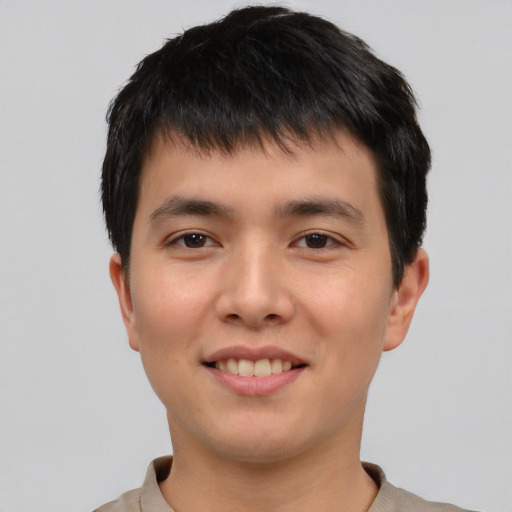 Joyful asian young-adult male with short  brown hair and brown eyes