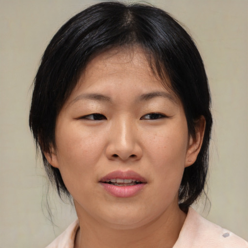 Joyful asian adult female with medium  brown hair and brown eyes