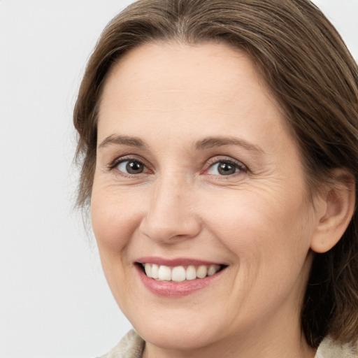 Joyful white adult female with medium  brown hair and grey eyes