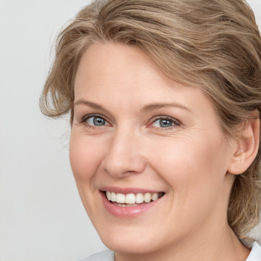 Joyful white young-adult female with medium  brown hair and blue eyes