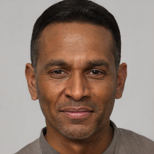 Joyful black adult male with short  black hair and brown eyes
