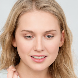 Joyful white young-adult female with long  brown hair and blue eyes