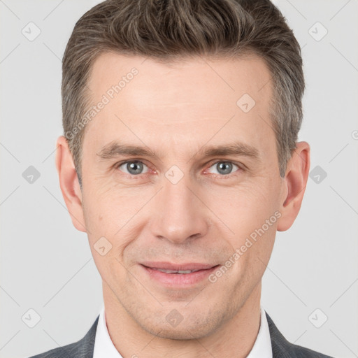 Joyful white adult male with short  brown hair and grey eyes