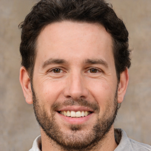 Joyful white adult male with short  brown hair and brown eyes