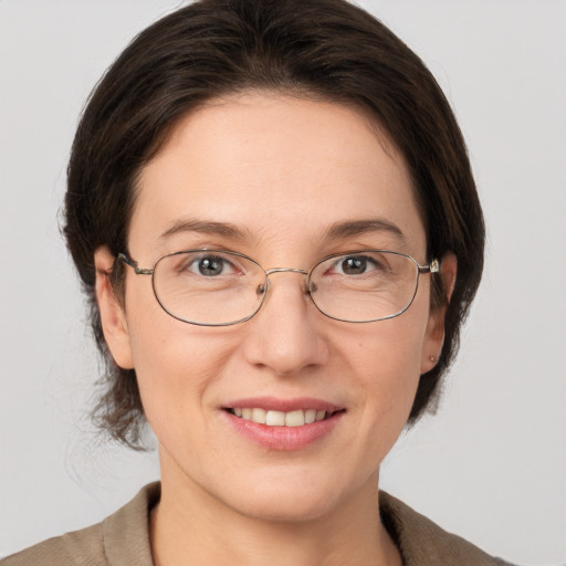 Joyful white adult female with medium  brown hair and grey eyes