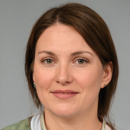 Joyful white young-adult female with medium  brown hair and green eyes