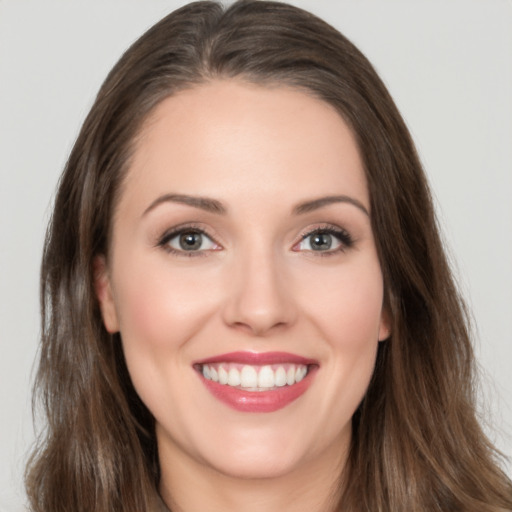 Joyful white young-adult female with long  brown hair and green eyes