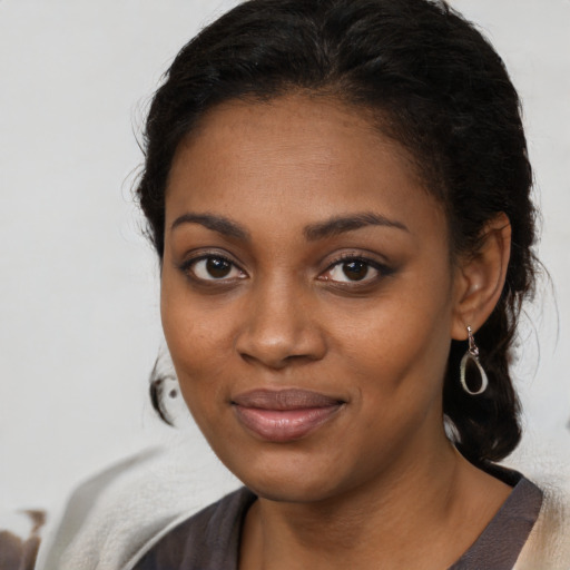 Joyful black young-adult female with long  brown hair and brown eyes