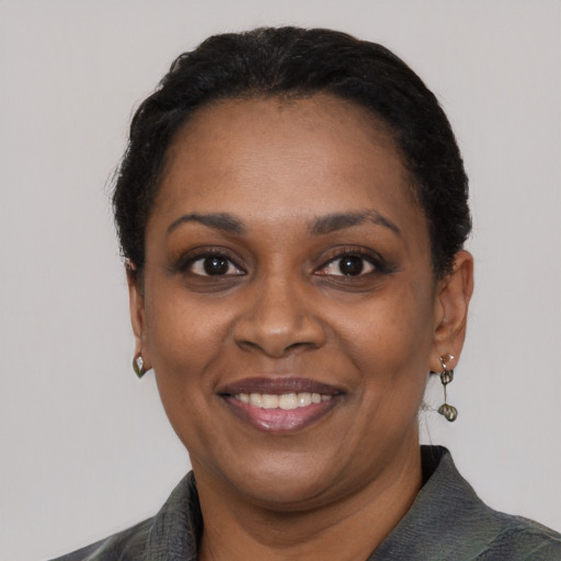 Joyful black adult female with short  black hair and brown eyes
