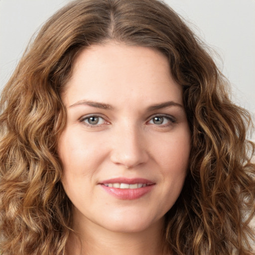 Joyful white young-adult female with long  brown hair and green eyes