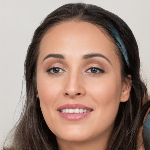 Joyful white young-adult female with long  brown hair and brown eyes