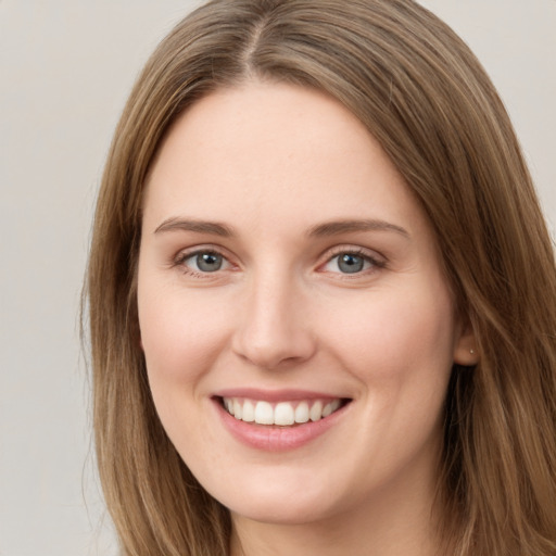 Joyful white young-adult female with long  brown hair and green eyes