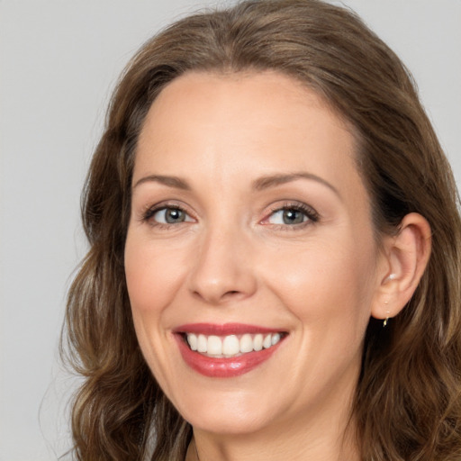 Joyful white adult female with long  brown hair and brown eyes