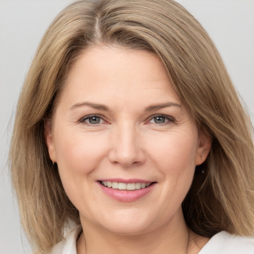 Joyful white adult female with medium  brown hair and brown eyes