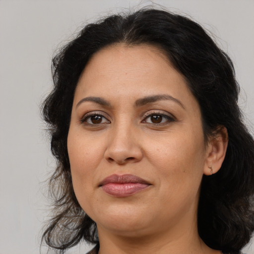 Joyful latino adult female with medium  brown hair and brown eyes