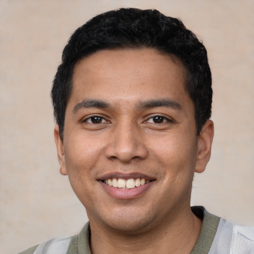 Joyful latino young-adult male with short  black hair and brown eyes