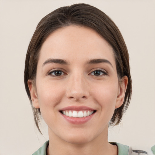 Joyful white young-adult female with medium  brown hair and grey eyes