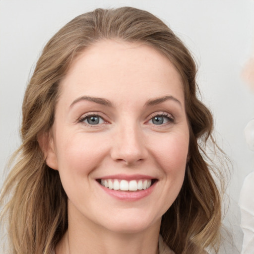 Joyful white young-adult female with long  brown hair and blue eyes