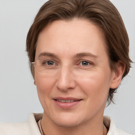 Joyful white adult female with medium  brown hair and grey eyes