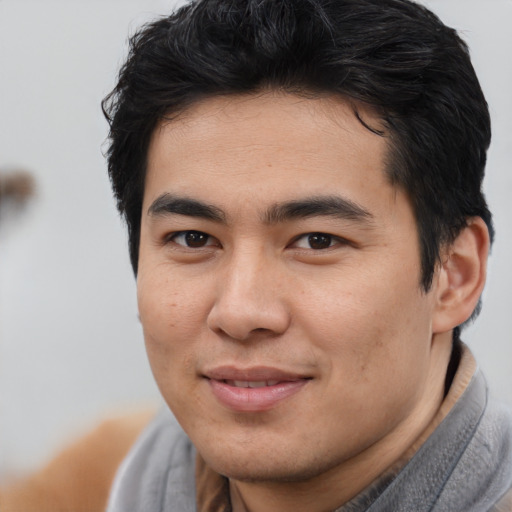 Joyful asian young-adult male with short  brown hair and brown eyes