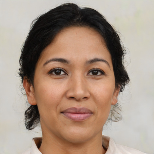 Joyful latino adult female with medium  brown hair and brown eyes