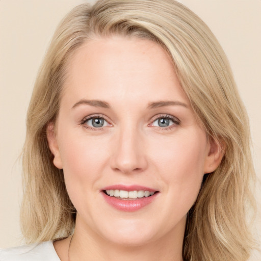 Joyful white young-adult female with long  brown hair and blue eyes