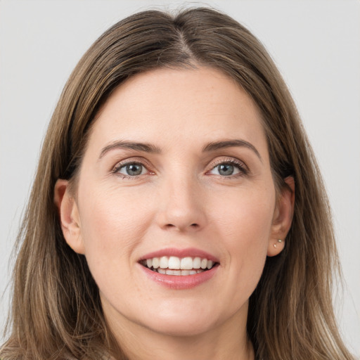 Joyful white young-adult female with long  brown hair and grey eyes