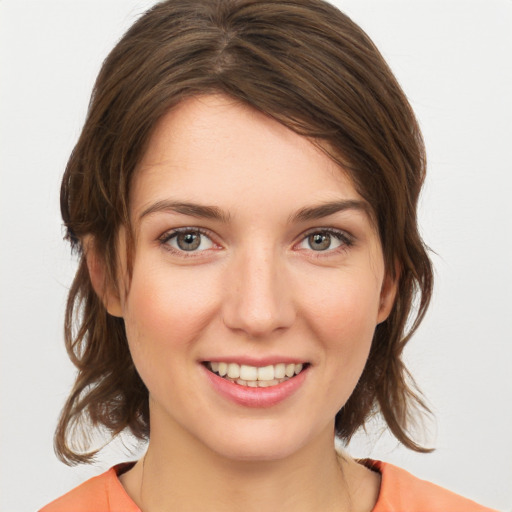 Joyful white young-adult female with medium  brown hair and grey eyes