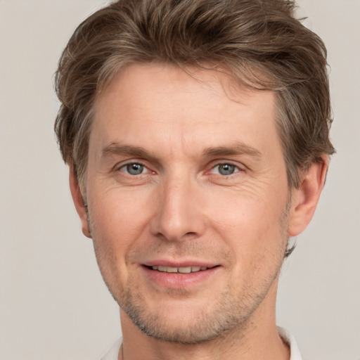 Joyful white adult male with short  brown hair and grey eyes