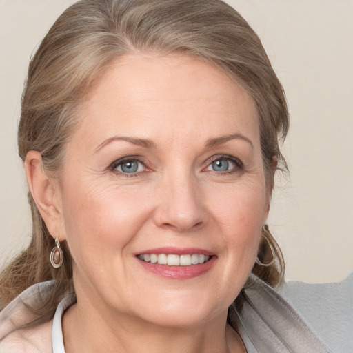 Joyful white adult female with medium  brown hair and grey eyes