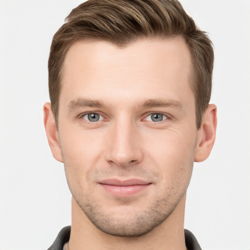 Joyful white young-adult male with short  brown hair and grey eyes