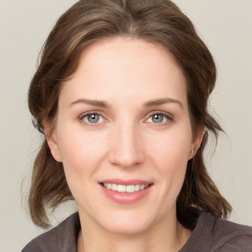 Joyful white young-adult female with medium  brown hair and grey eyes