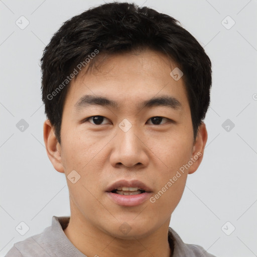 Joyful asian young-adult male with short  black hair and brown eyes