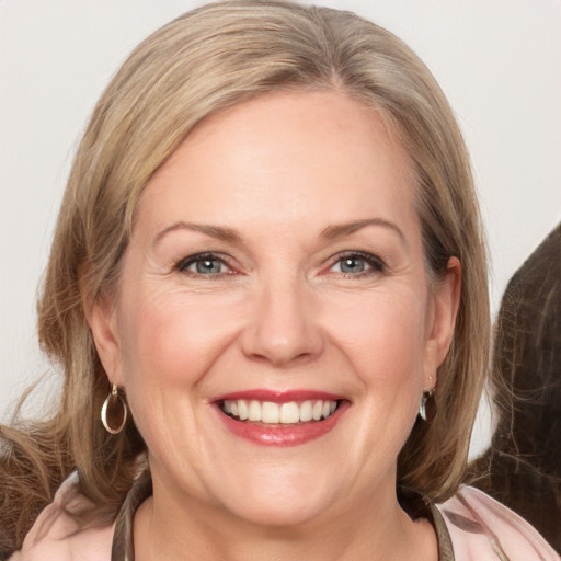 Joyful white adult female with medium  brown hair and grey eyes