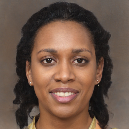 Joyful black young-adult female with long  brown hair and brown eyes