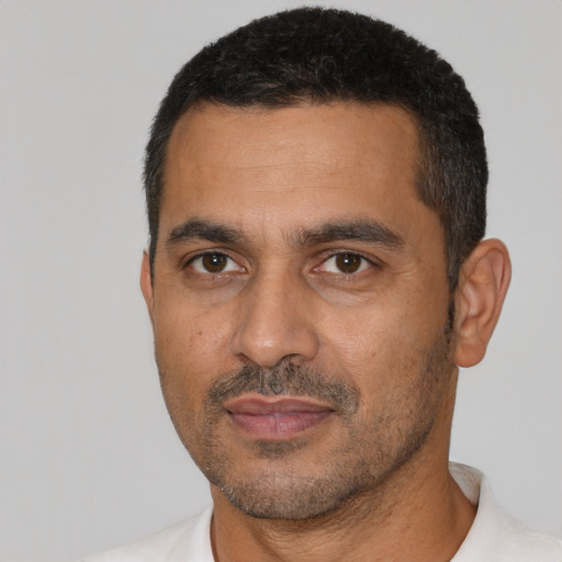 Joyful latino adult male with short  black hair and brown eyes