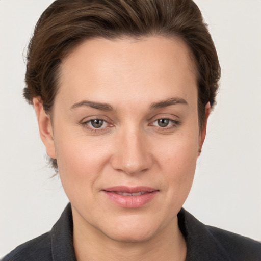 Joyful white young-adult female with medium  brown hair and grey eyes