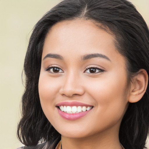 Joyful latino young-adult female with long  brown hair and brown eyes