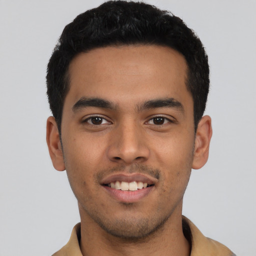 Joyful latino young-adult male with short  black hair and brown eyes