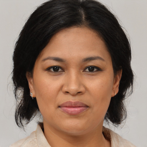 Joyful latino adult female with medium  brown hair and brown eyes