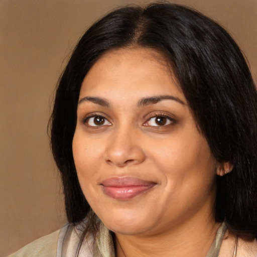 Joyful latino adult female with medium  brown hair and brown eyes