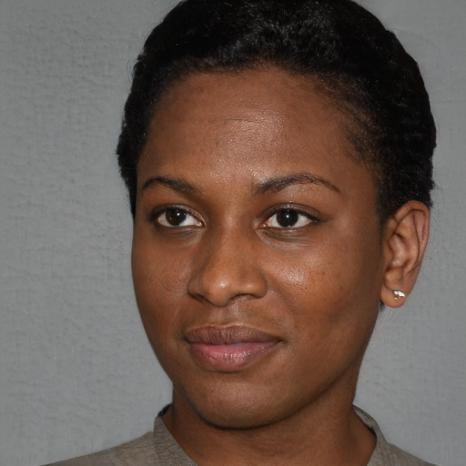 Joyful black young-adult female with short  black hair and brown eyes