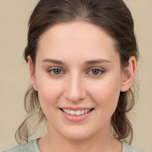 Joyful white young-adult female with medium  brown hair and grey eyes