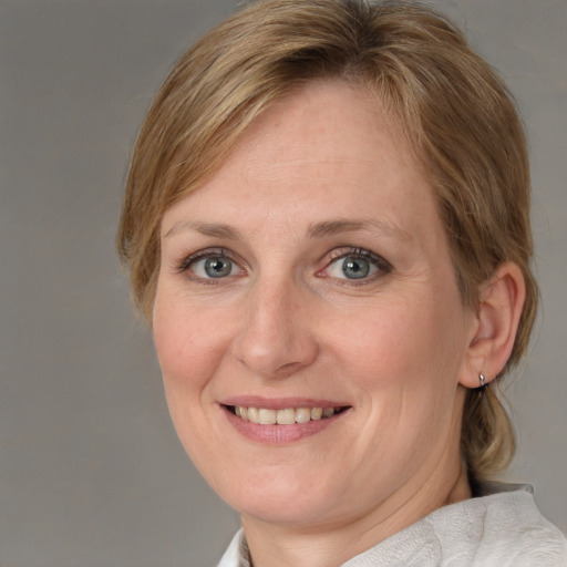 Joyful white adult female with medium  brown hair and blue eyes