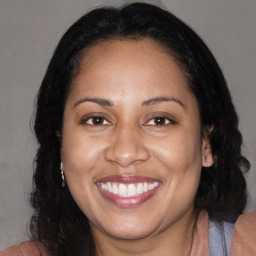 Joyful black adult female with long  brown hair and brown eyes