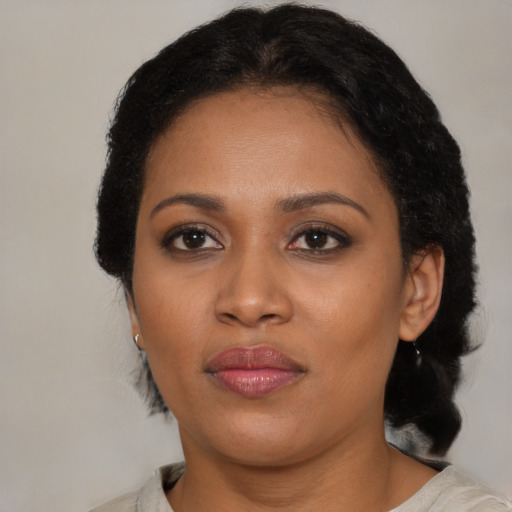 Joyful black young-adult female with medium  black hair and brown eyes