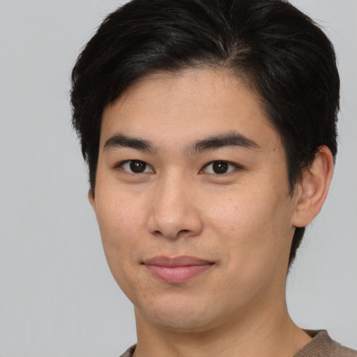 Joyful asian young-adult male with medium  brown hair and brown eyes